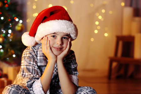 Little boy sitting near fireplace in room
