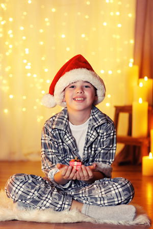 Little boy sitting near fireplace in roomの写真素材