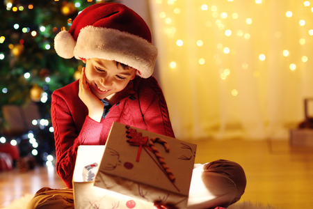 Little boy sitting near fireplace in roomの写真素材