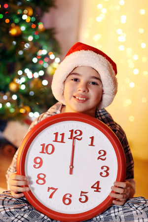 Little boy sitting near fireplace in roomの写真素材