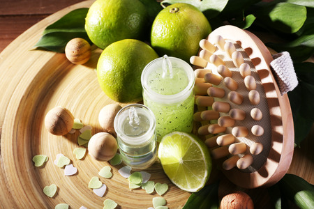 Spa composition with lime on wooden plate and wooden table backgroundの写真素材
