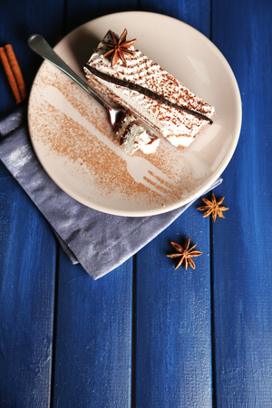 Tasty tiramisu cake on plate, on wooden tableの写真素材