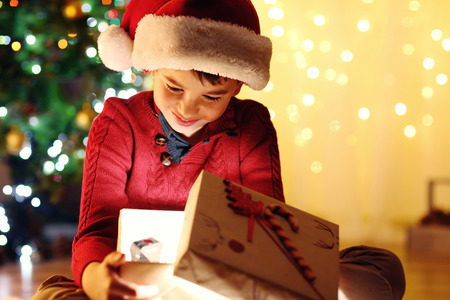 Little boy sitting near fireplace in roomの写真素材