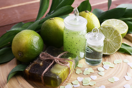 Spa composition with lime on wooden plate and wooden table backgroundの写真素材