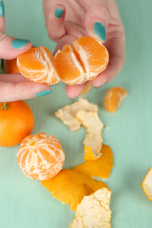 Hands holding ripe tangerine, close upの写真素材