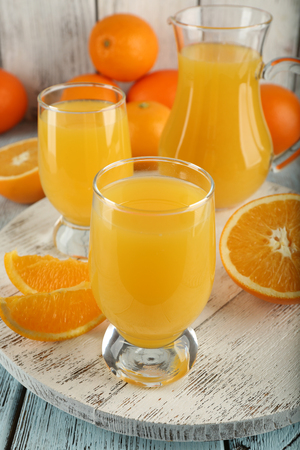 Glass of orange juice with slices on color wooden backgroundの写真素材