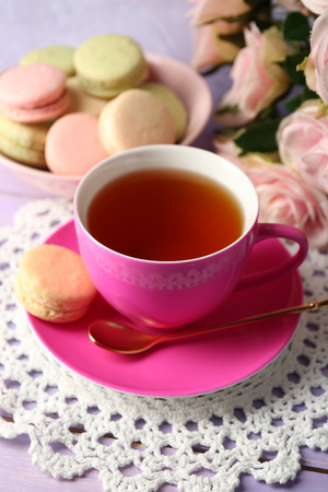 Colorful macaroons with cup of tea on wooden backgroundの写真素材
