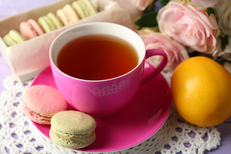 Colorful macaroons with cup of tea on wooden backgroundの写真素材