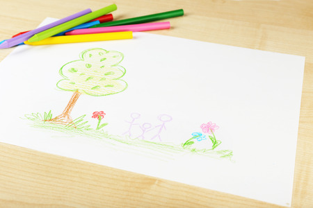Drawing made by child with colorful pencils on wooden table backgroundの写真素材