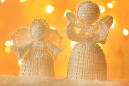 Knitted Christmas angels on bright backgroundの写真素材
