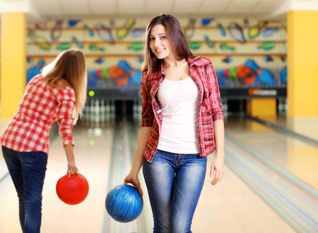 Young women holding bowling ball in clubの写真素材