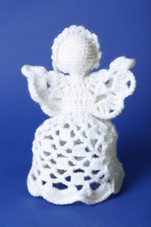 Knitted Christmas angel on color backgroundの写真素材