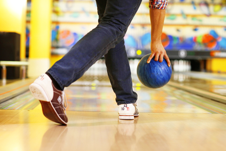 Male legs and bowling ball in alley backgroundの写真素材