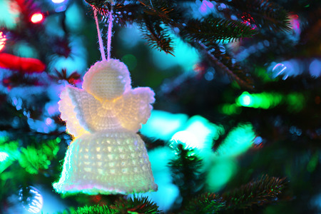 Knitted Christmas angel on Christmas lights backgroundの写真素材