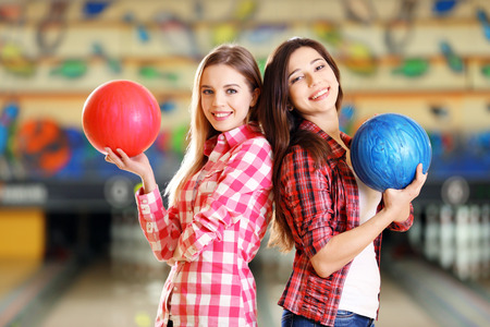 Young women holding bowling ball in clubの写真素材