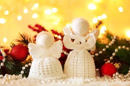 Knitted Christmas angels on bright backgroundの写真素材