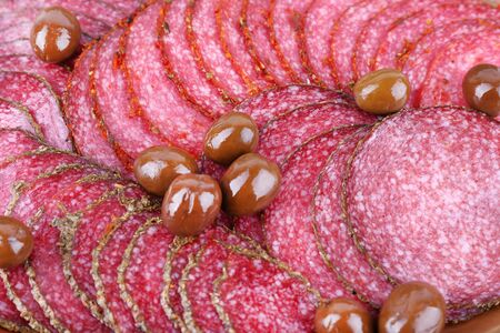 Slices of salami with olives, macro view