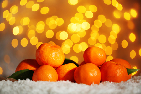 Fresh ripe mandarins on snow, on lights backgroundの写真素材