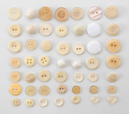 Beige sewing buttons isolated on white