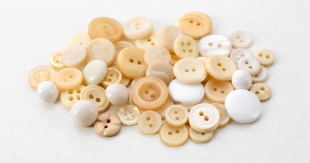 Beige sewing buttons isolated on white