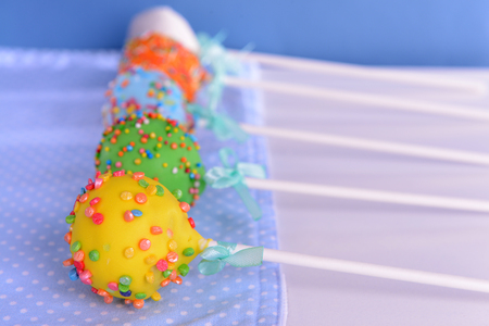 Sweet cake pops on table on blue backgroundの写真素材