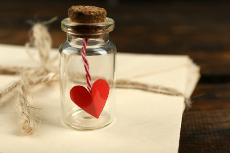 Stack of love letters with little bottle on rustic wooden table backgroundの写真素材
