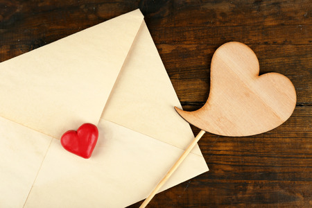 Envelope with hearts on rustic wooden table background
