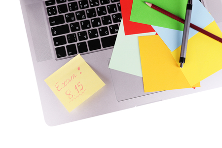 Laptop with sheet of paper and note Exam, on white backgroundの写真素材