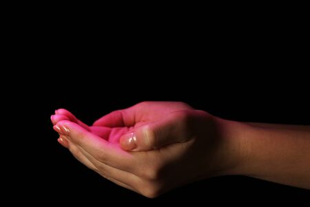 Female hands on dark backgroundの写真素材