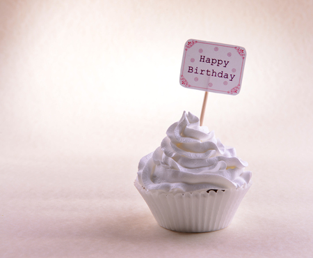 Delicious cupcake with inscription on table on beige backgroundの写真素材