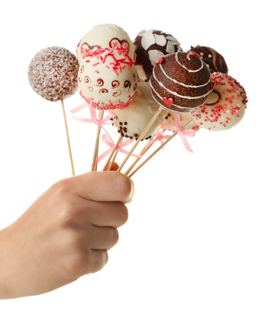 Female hand holding cake pops, isolated on whiteの写真素材
