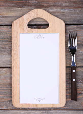 Cutting board with menu sheet of paper on rustic wooden planks backgroundの写真素材