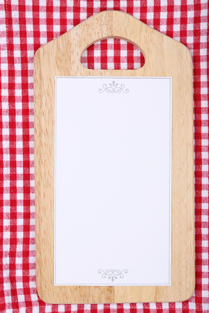 Cutting board with menu sheet of paper on squared fabric backgroundの写真素材