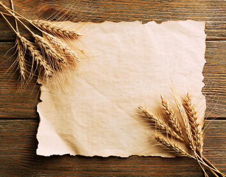 Spikelets of wheat with paper on wooden backgroundの写真素材