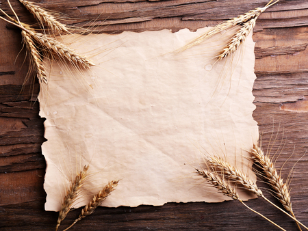 Spikelets of wheat with paper on wooden backgroundの写真素材