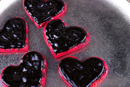 Cookies in form of heart covered chocolate on metal tray backgroundの写真素材