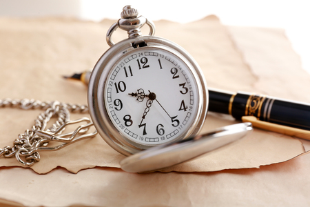 Silver pocket clock on old paper backgroundの写真素材