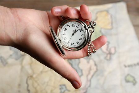 Silver pocket clock in hand closeup