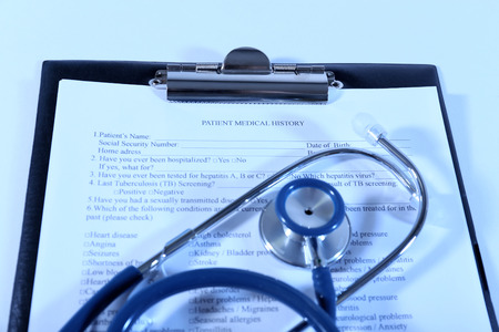 Medical history on clipboard with stethoscope on light backgroundの写真素材