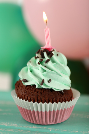 Delicious birthday cupcake on table on bright backgroundの写真素材