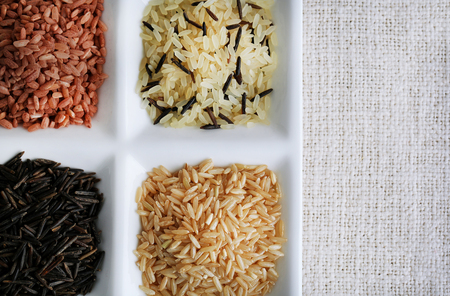 Different types of rice on plate on fabric backgroundの写真素材