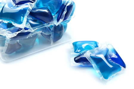 Gel capsules with laundry detergent isolated on whiteの写真素材