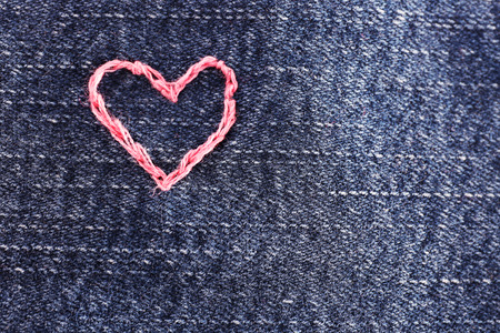 Jeans fabric with heart embroidered on it, close-upの写真素材