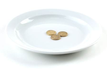 Coins on plate isolated on whiteの写真素材