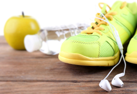 Sport shoes and bottle of water on light backgroundの写真素材