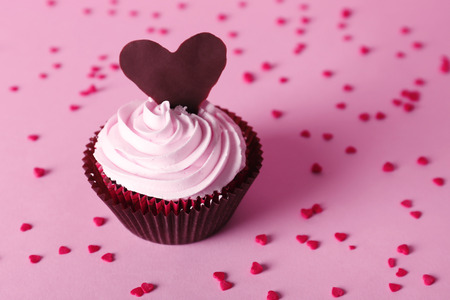 Delicious Valentine Day cupcake on pink backgroundの写真素材