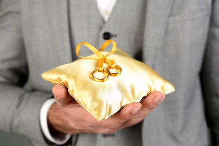 Man holding wedding rings close upの写真素材