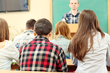 Group of students sitting in classroom and  listening teacherの写真素材