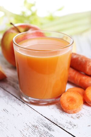Glass of juice with apple and carrot on wooden table close upの写真素材