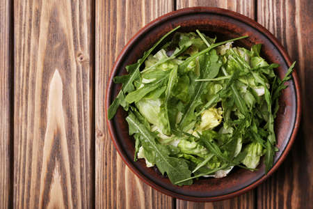 Lettuce with arugula in bowl on wooden backgroundの写真素材